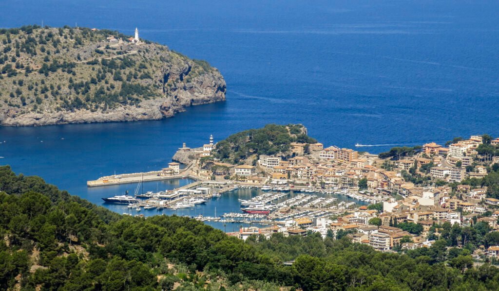 Panoramablick auf Puerto de Sóller auf Mallorca mit seinem Jachthafen, den traditionellen Häusern und dem Leuchtturm mit Blick auf das Mittelmeer.